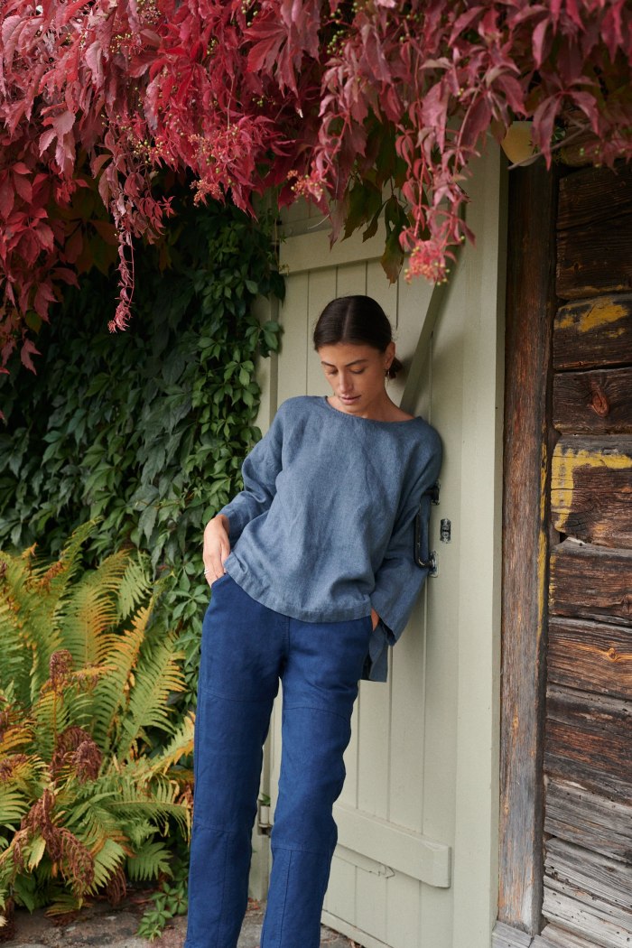 A model in a casual three quarter sleeve blue linen wool blend tunic and navy blue pants