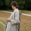 Side view of a long grey linen jacket unfastened