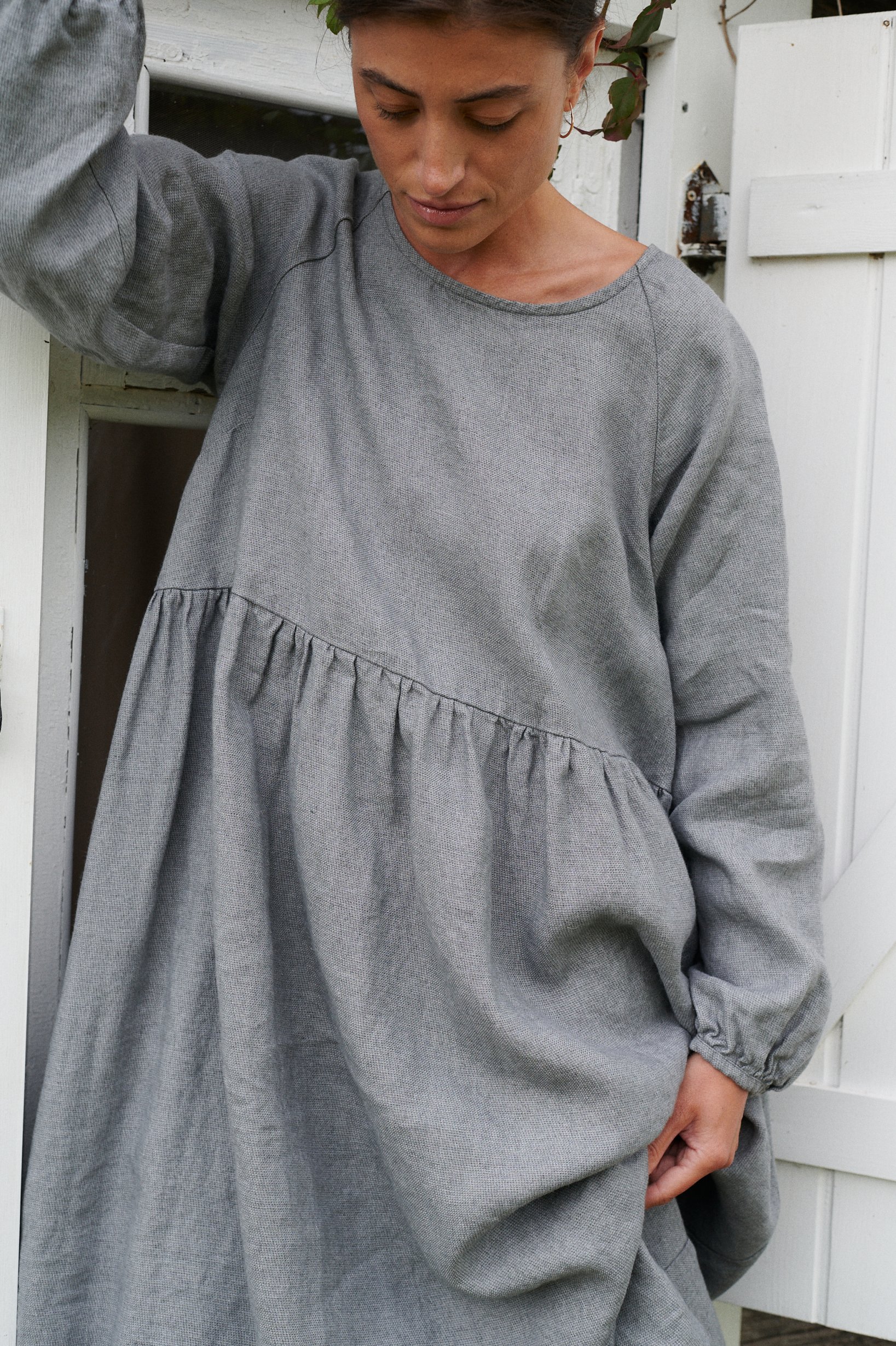 A woman in long smock dress in grey linen wool blend