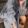 A woman in long sleeve smock dress in grey linen wool blend