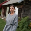 Woman wearing a grey linen wool blend oversized jacket with a matching belt tied around the waist