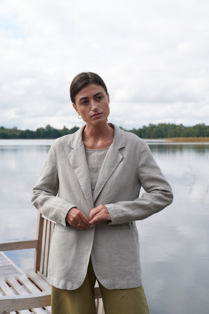 Model in a natural grey linen blazer with a button and pockets