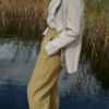 The side pockets of heavy linen high waisted pants in olive