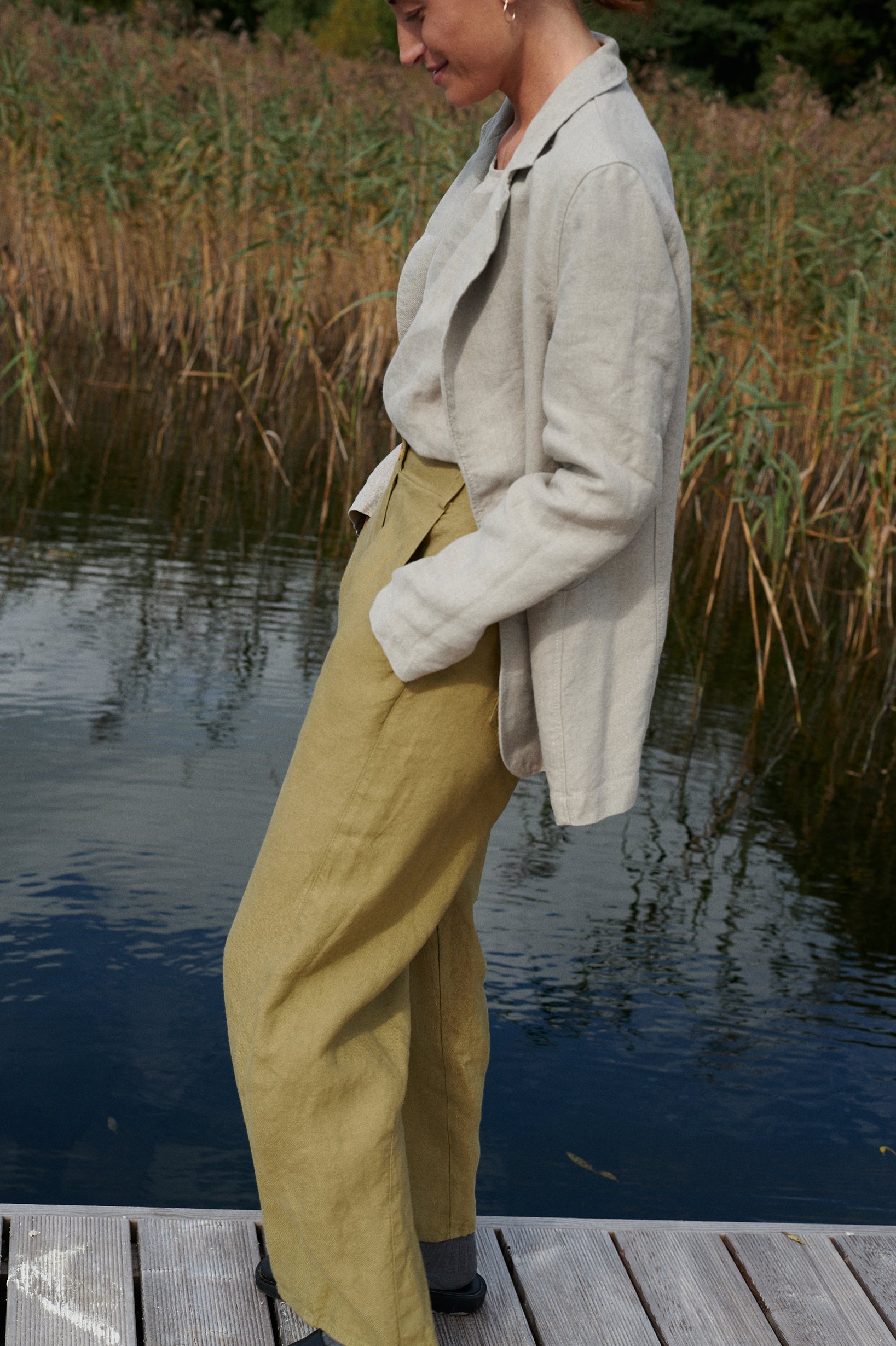 The side pockets of heavy linen high waisted pants in olive