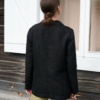 Back view of a loose-fitting black heavy linen blazer