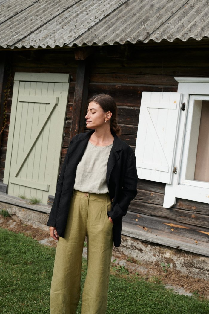 Model in an oversized black linen blazer and green linen trousers outfit