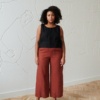 front of model in terracotta wide leg linen trousers paired with a black linen summer top with wide straps