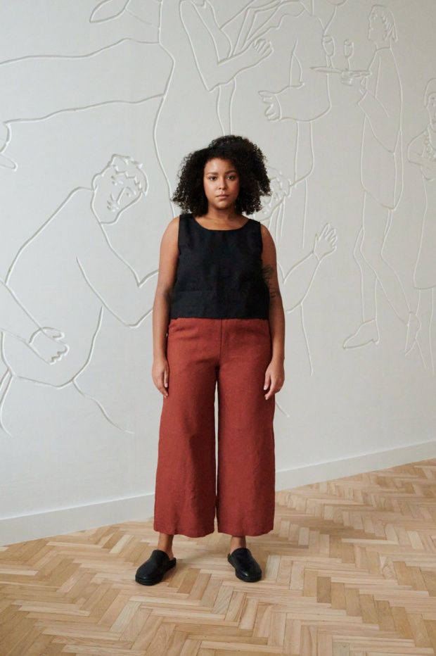 front of model in terracotta wide leg linen trousers paired with a black linen summer top with wide straps