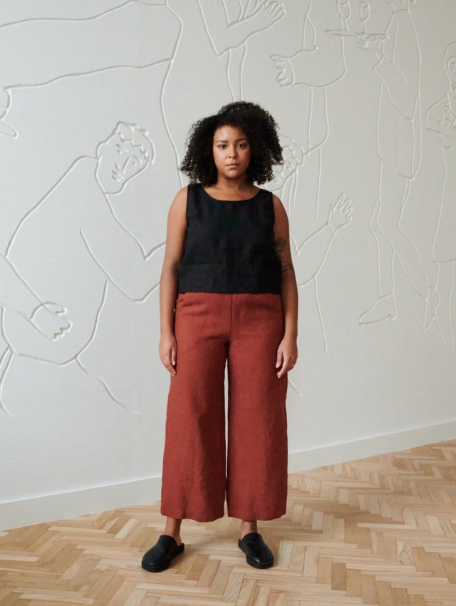 front of model in terracotta wide leg linen trousers paired with a black linen summer top with wide straps