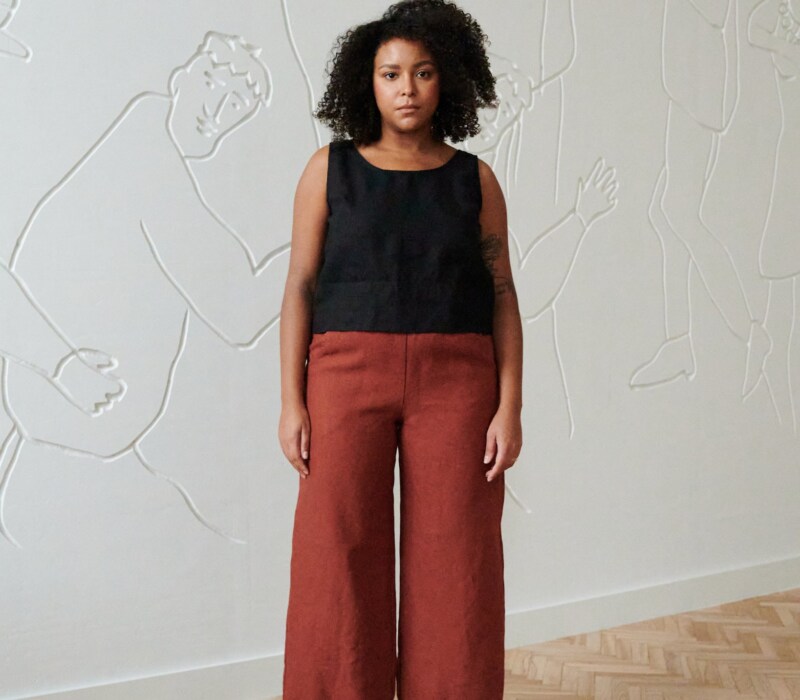 front of model in terracotta wide leg linen trousers paired with a black linen summer top with wide straps