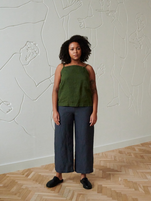 Front of a model in a linen summer top with thin straps and wide leg linen trousers outfit