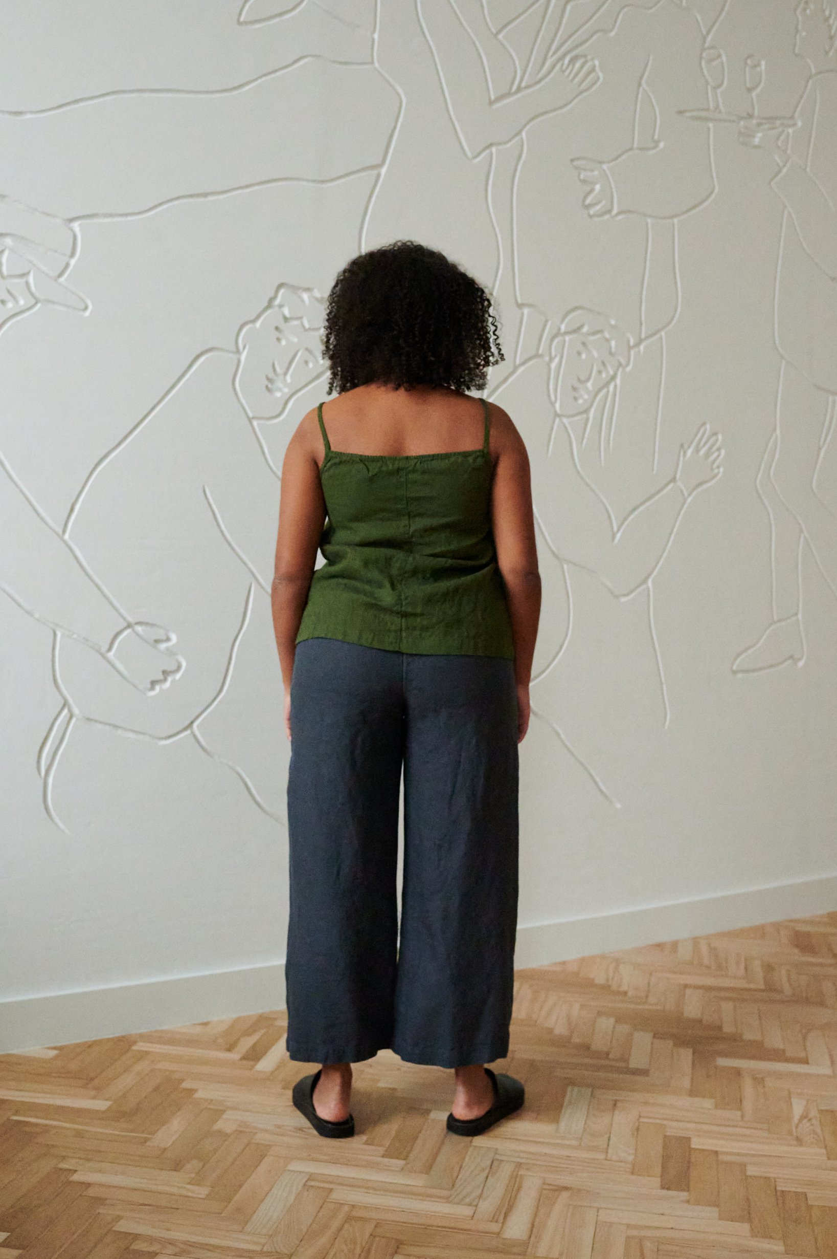 Back of a model wearing a casual strapless linen top and and wide leg linen trousers