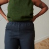 A sleeveless linen top tucked into an elasticated waist of linen trousers