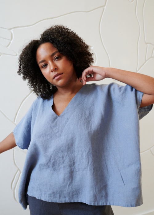 Model wearing a loose-fitting linen top with a V neckline