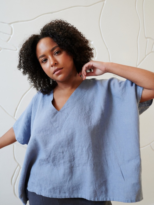 Model wearing a loose-fitting linen top with a V neckline