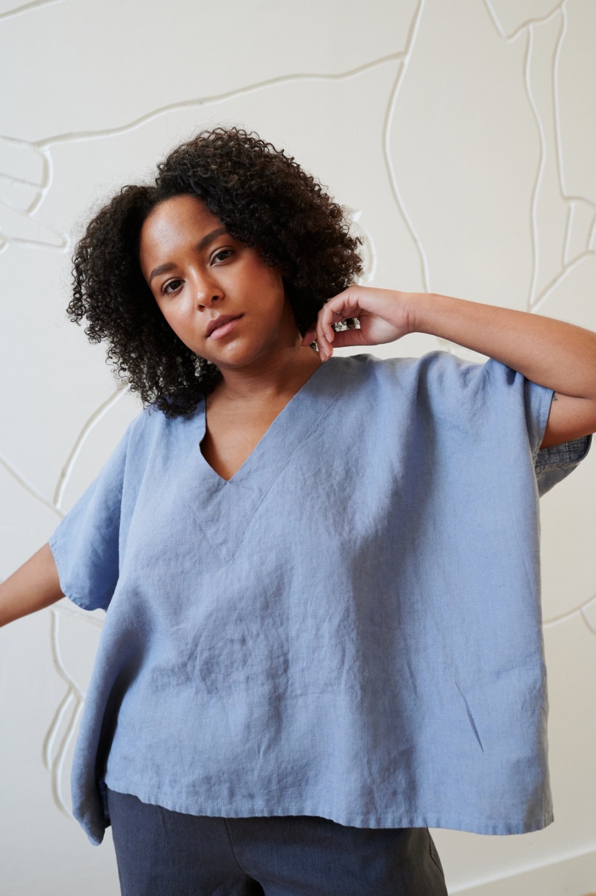 Model wearing a loose-fitting linen top with a V neckline