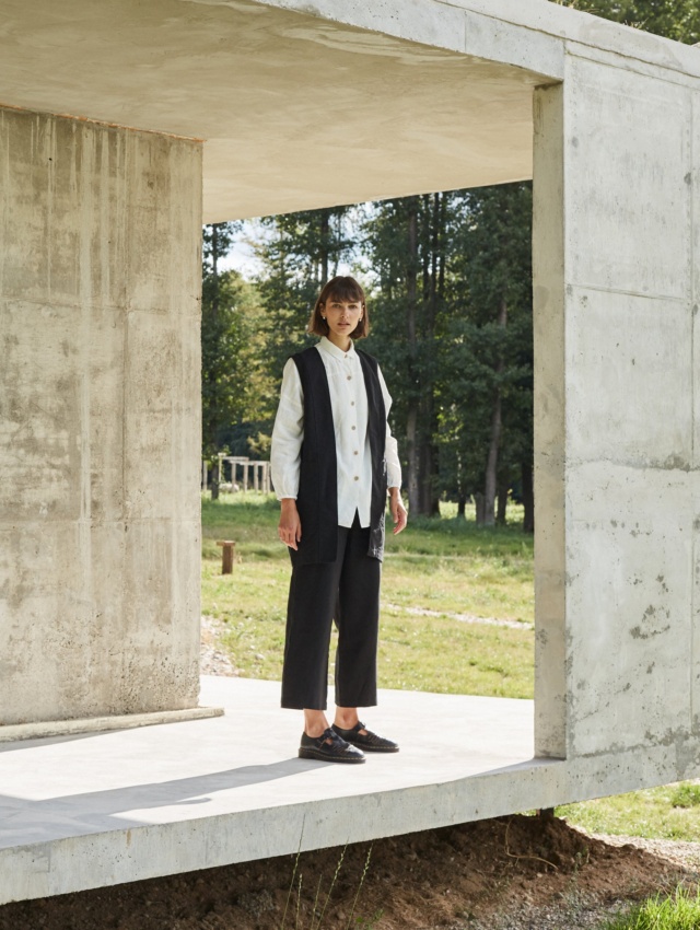 A woman standing in black heavy linen wide leg pants