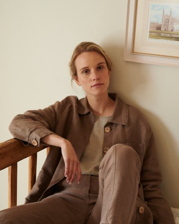 Woman sitting in an all linen outfit wearing ççç and trousers