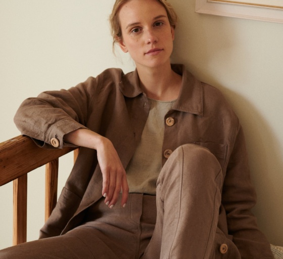 Woman sitting in an all linen outfit wearing ççç and trousers