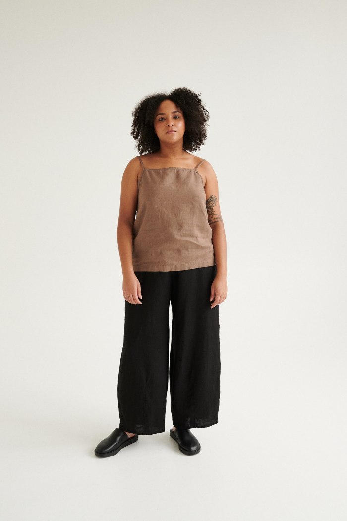A woman in high waisted black linen trousers