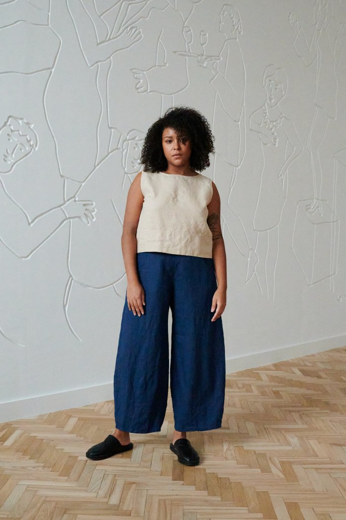 Front of a woman wearing a casual sleeveless linen top and barrel leg linen trousers outfit