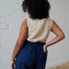 Back of a model in a beige linen to and high waisted linen trousers with back pockets