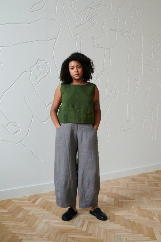 A woman in a casual sleeveless linen top and barrel leg linen trousers with pockets