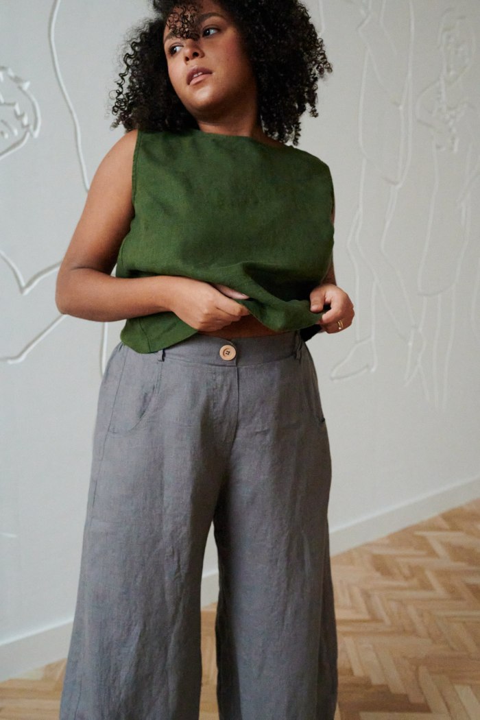 A green sleeveless casual linen top and grey high waisted linen trousers outfit