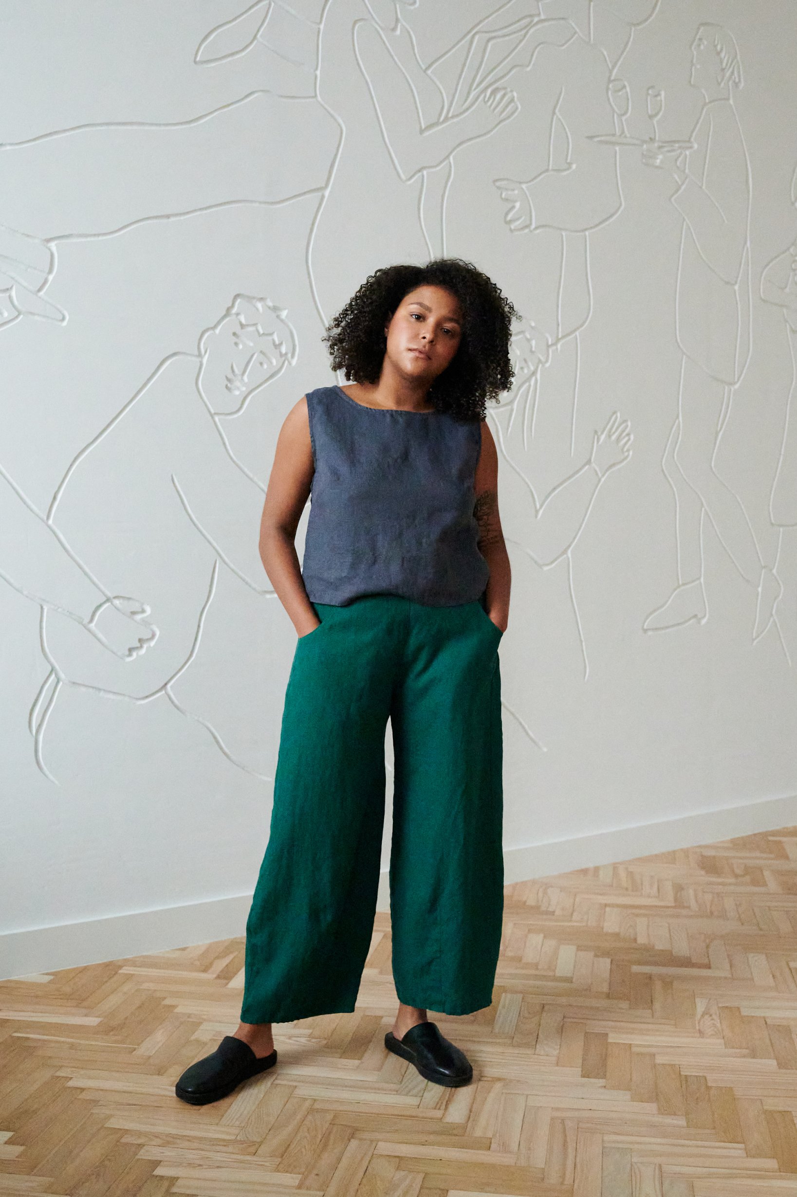 Model in a cropped casual sleeveless linen top and wide leg linen trousers