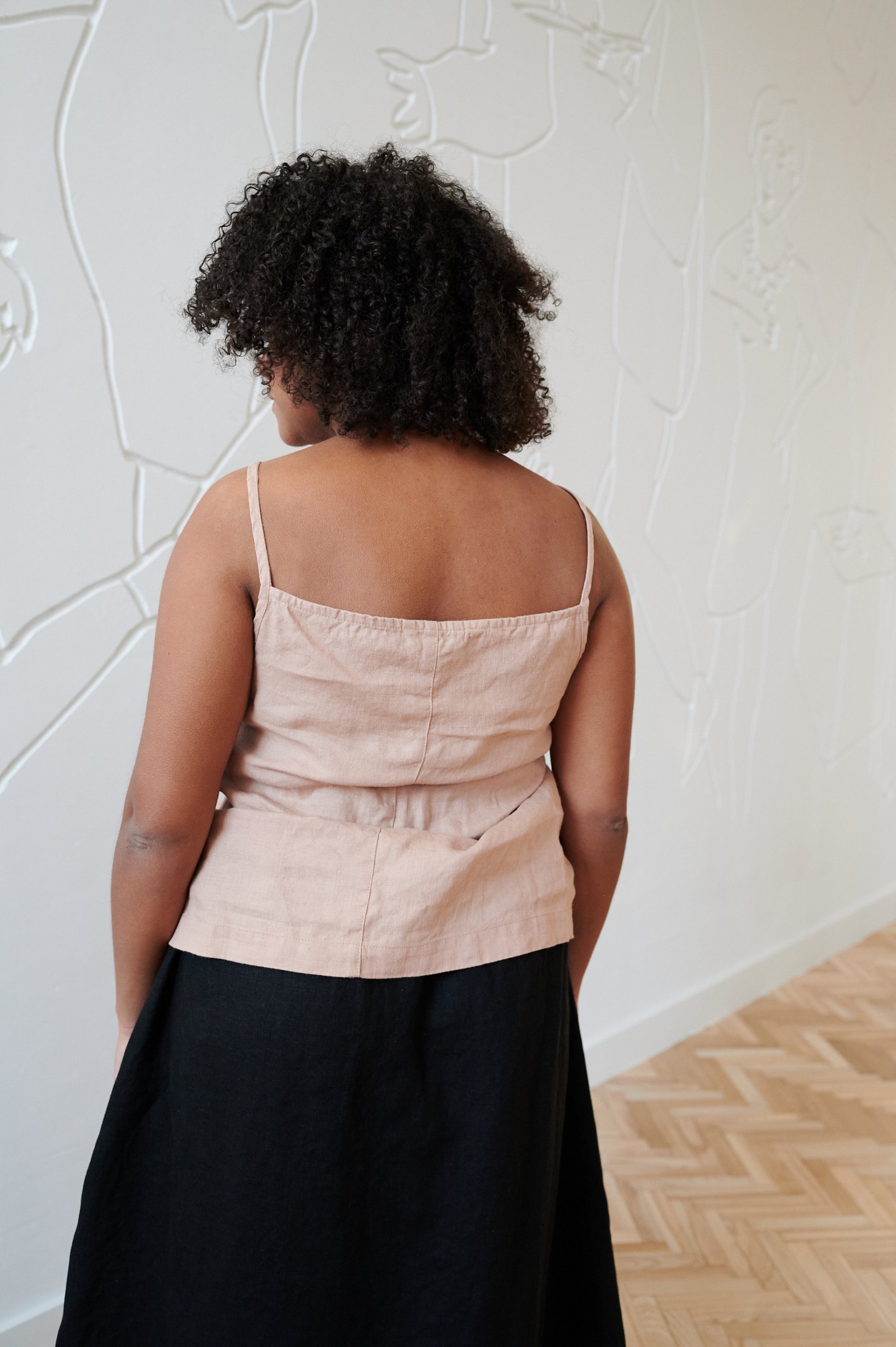 Back of a model wearing a linen summer top with spaghetti straps