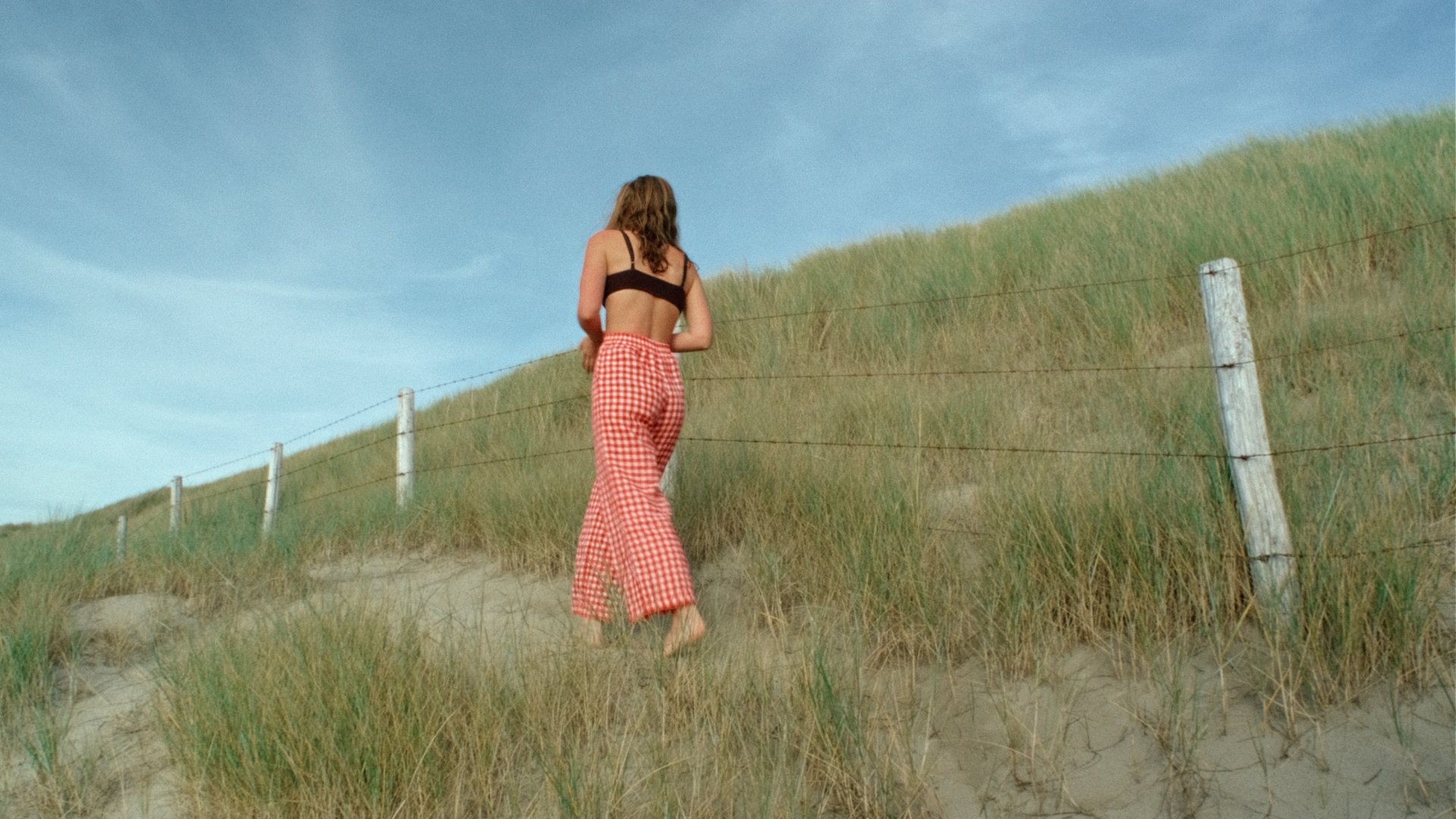 woman wearing linen trousers red gingham by the sea summer linens