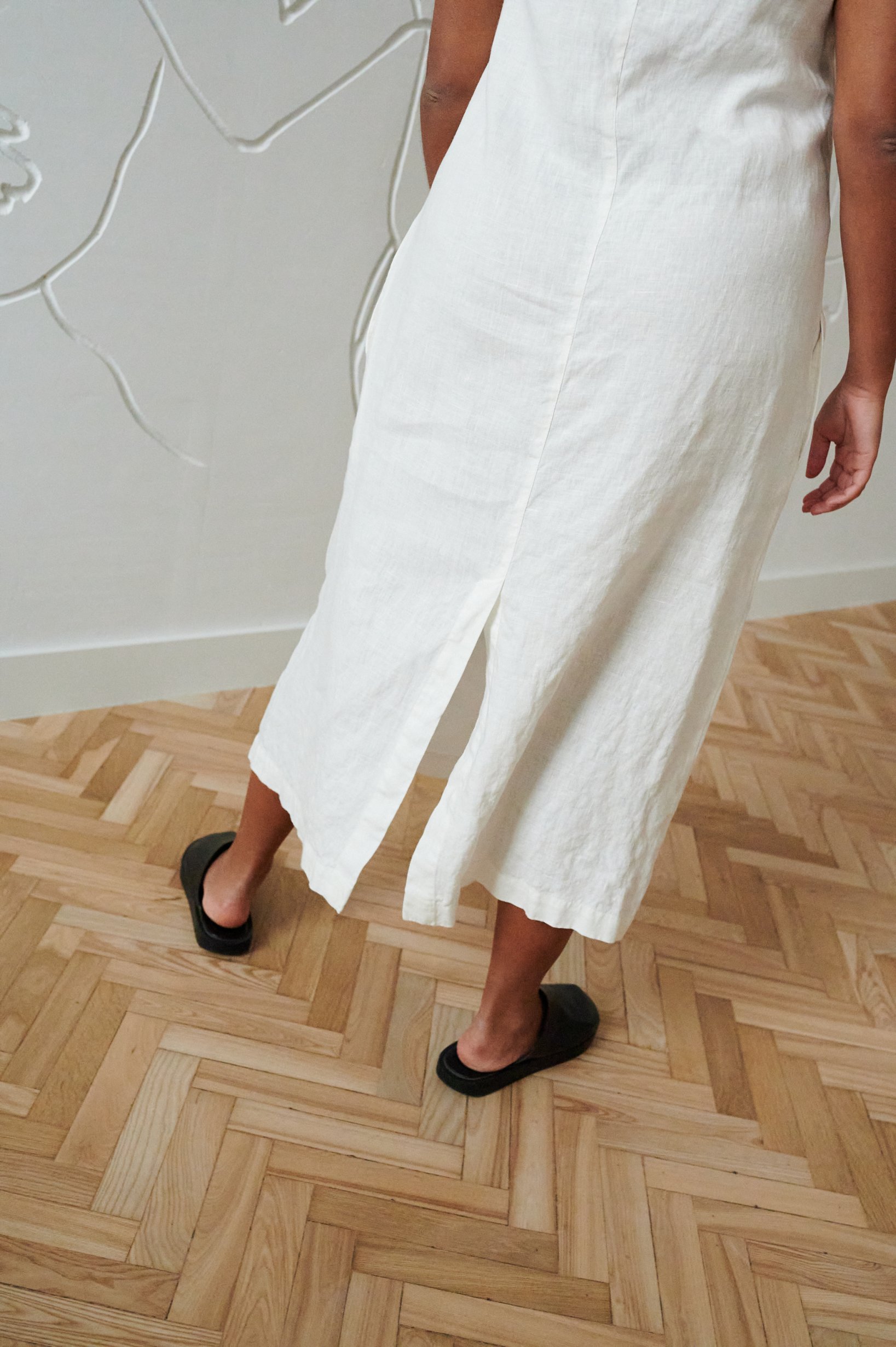 Bottom details of a long linen dress with a slit in the back