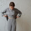 Woman wearing grey high waisted linen trousers and a matching oversized linen tunic