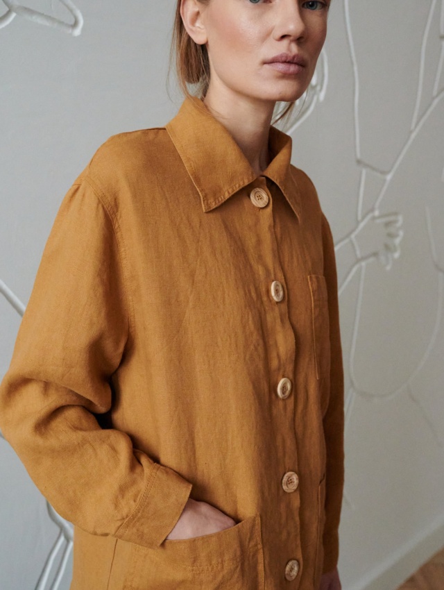 Woman wearing a loose-fitting linen utility jacket with wooden buttons