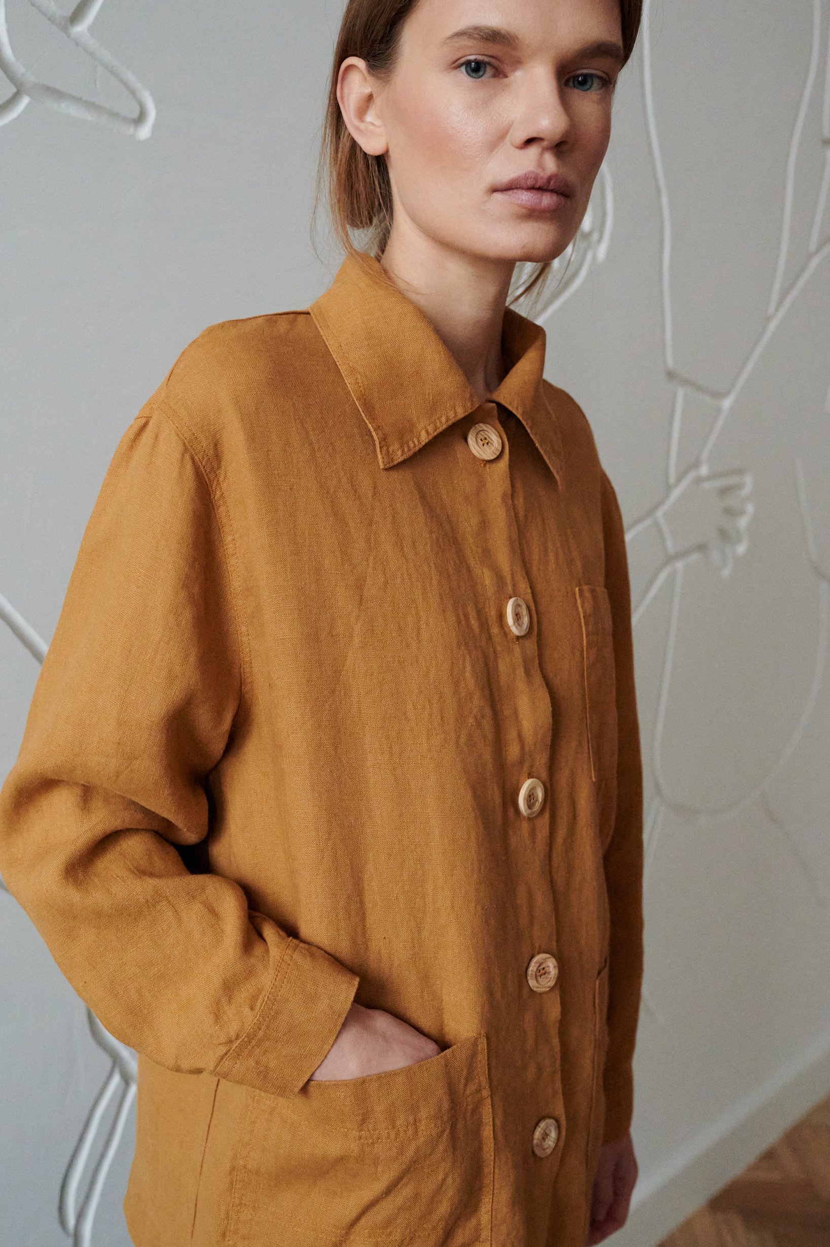 Woman wearing a loose-fitting linen utility jacket with wooden buttons