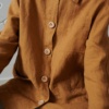 An oversized linen jacket with three patch pockets and wooden buttons