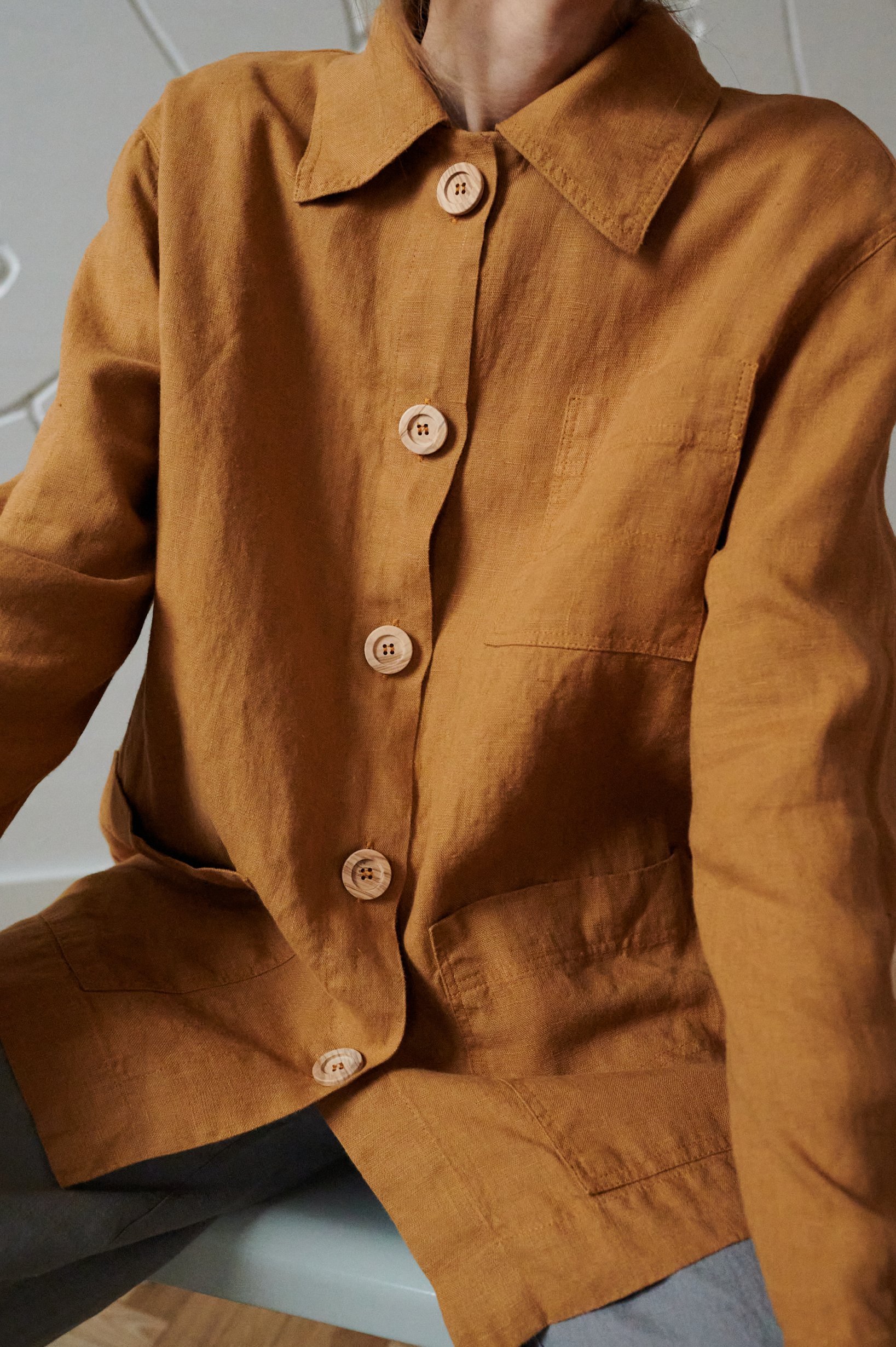 An oversized linen jacket with three patch pockets and wooden buttons