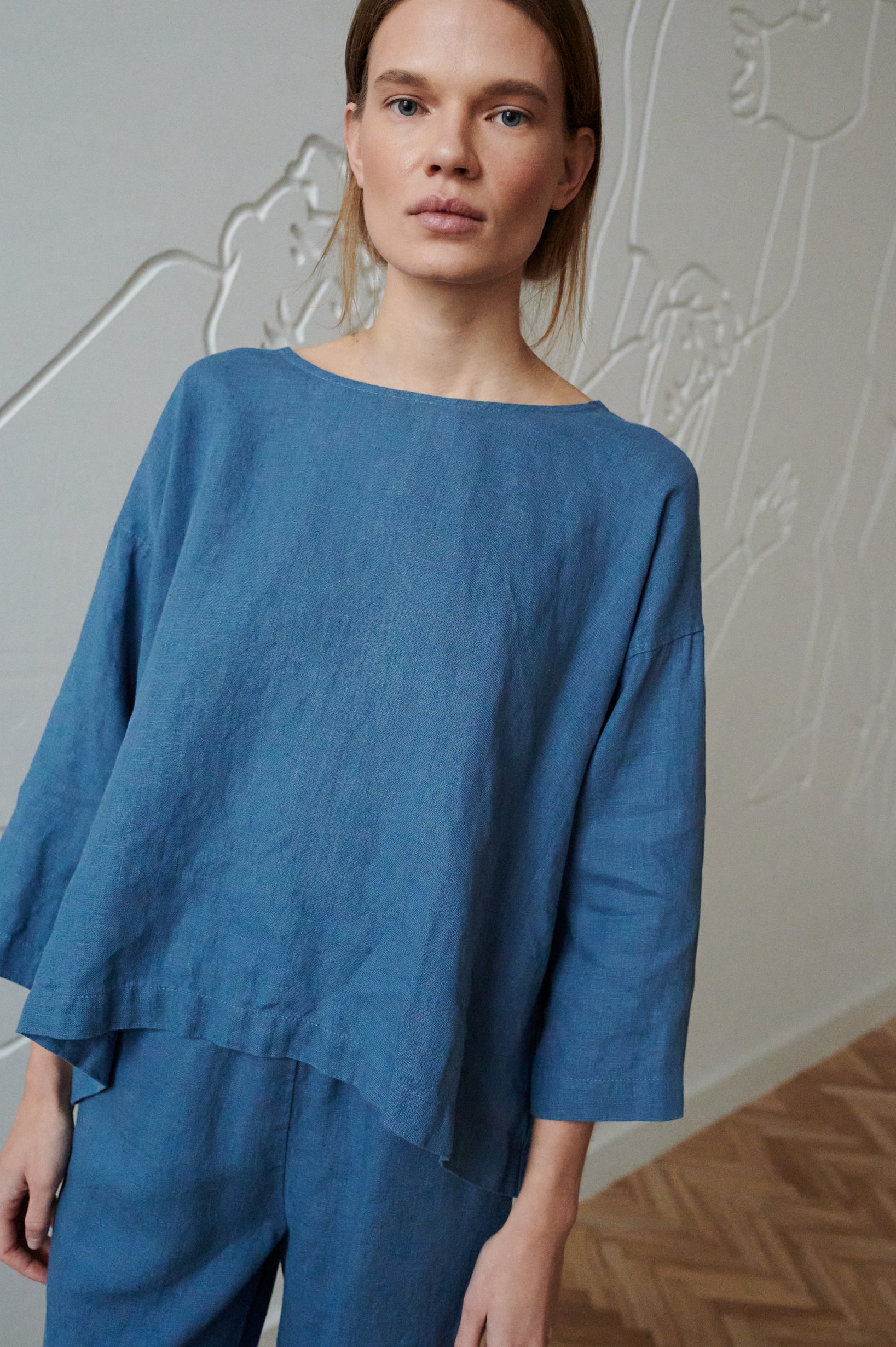A loose-fitting blue linen tunic with a round neck