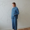 Linenfox model wearing a loose-fitting blue linen utility jacket and matching wide-leg linen trousers