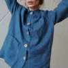 Model wearing a loose-fitting linen jacket with three patch pockets