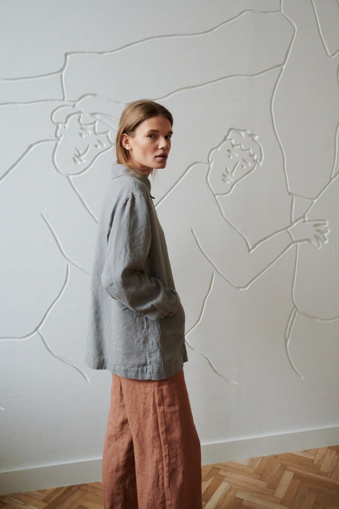 Side view of a model in an oversized linen jacket with a folded collar
