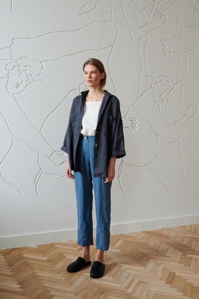 Model in a relaxed fit linen shirt and cropped loose-fitting linen trousers