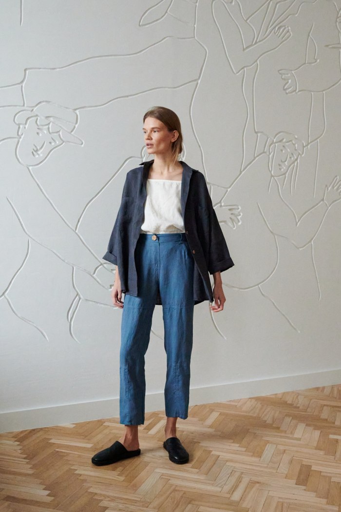 Model wearing loose-fitting cropped linen trousers and a linen shirt outfit