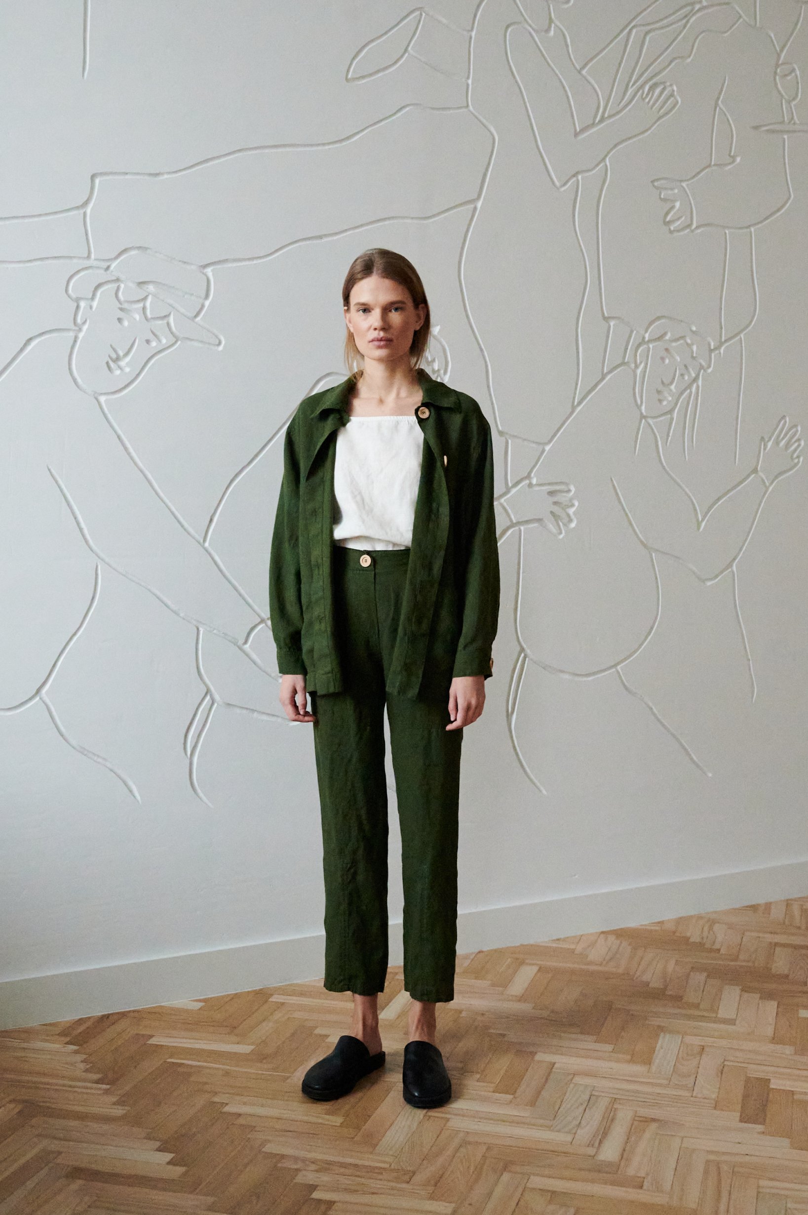 Model wearing loose-fitting linen trousers and an oversized linen jacket with a linen summer top underneath