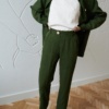 High-waisted green linen trousers and a matching linen jacket worn unbuttoned