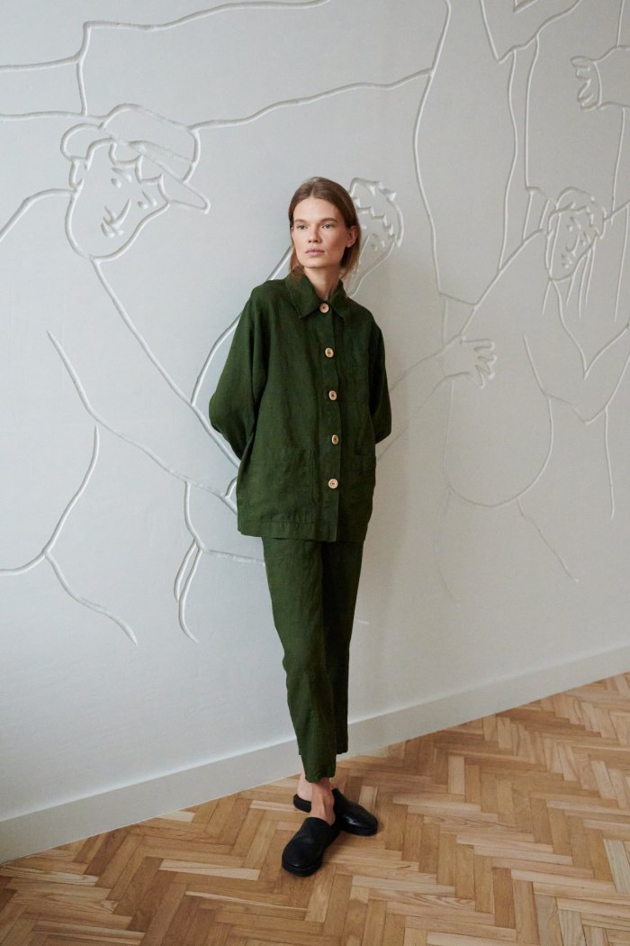 Woman wearing a dark green utility jacket and linen trousers outfit