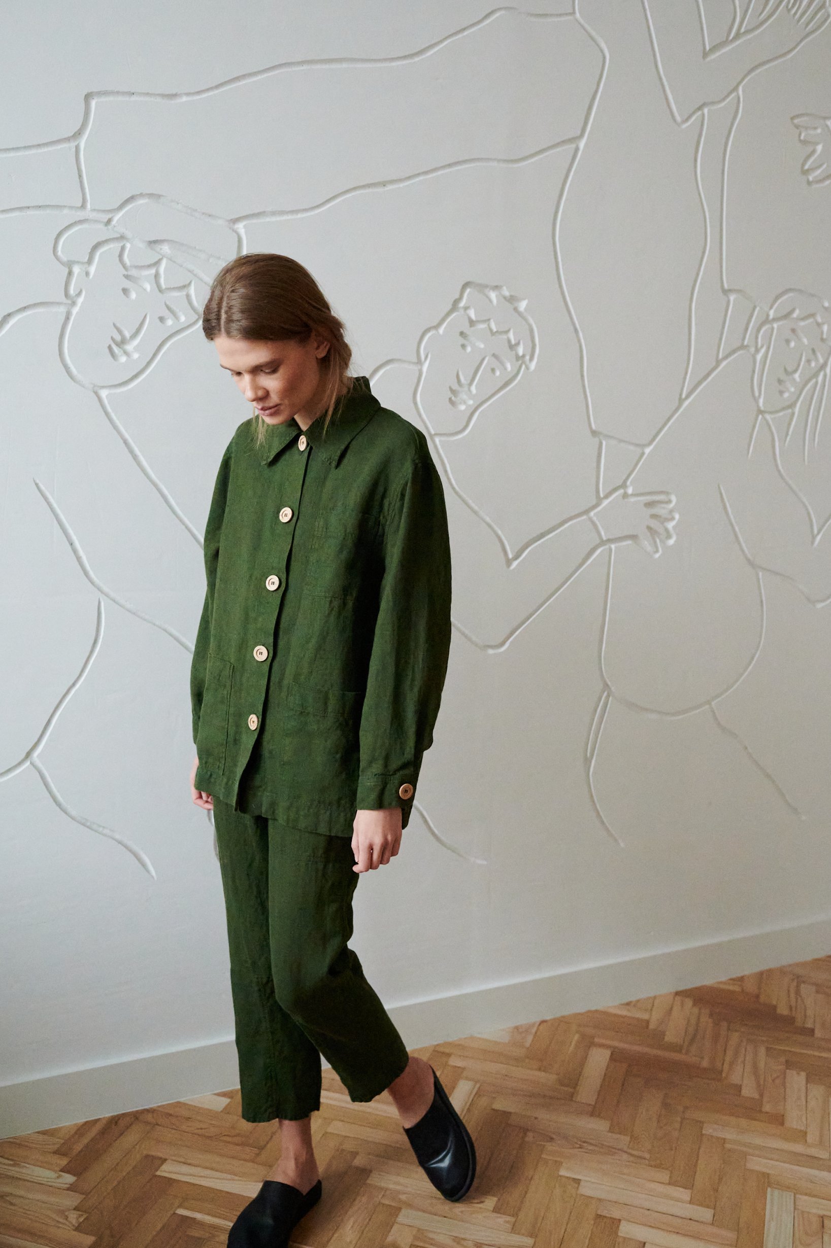 Linenfox model wearing a green loose-fitting linen utility jacket and matching linen trousers outfit