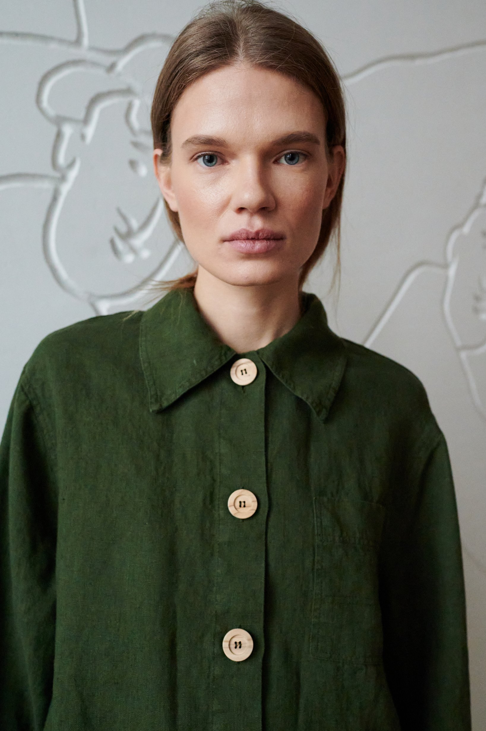 A dark green linen utility style jacket with wooden buttons