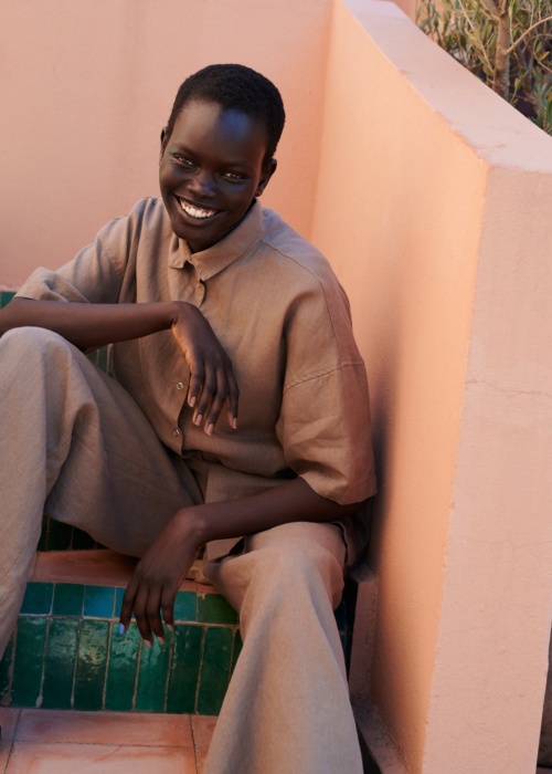model wearing a linen set of short-sleeved linen shirt, and wide leg trousers in mocha mousse