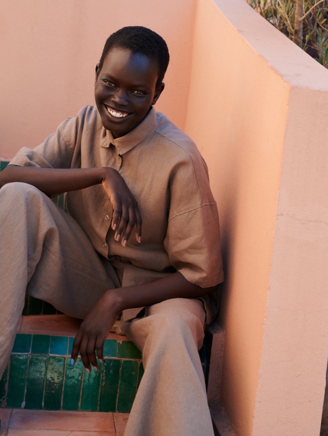 model wearing a linen set of short-sleeved linen shirt, and wide leg trousers in mocha mousse